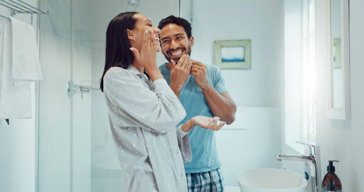 Couple getting ready in bathroom.