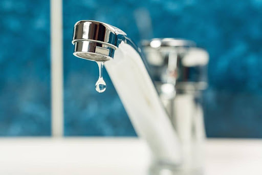 A drop of water drips from a leaky faucet.