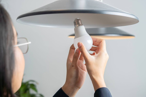 Homeowner installing light bulb.