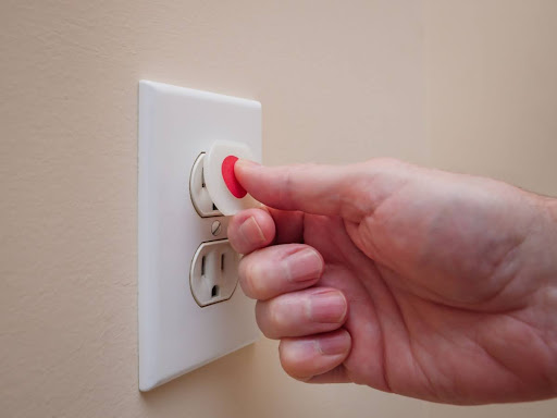 Homeowner childproofing electrical outlets.